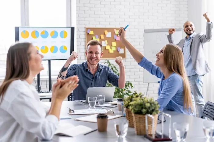trabajadores celebrando porque cumplieron con la meta empresarial