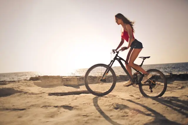mujer en bicicleta en la costa