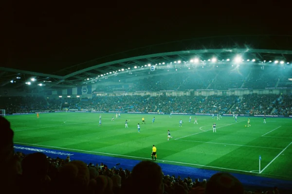 Partido de fútbol en un estadio iluminado por la noche